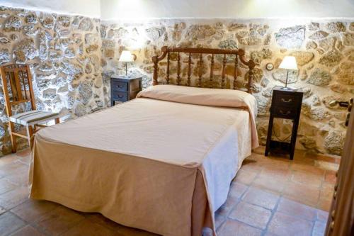 CaleruelaにあるUn espacio único, 'La Casona del Señor' con bodegaの石壁のベッドルーム1室(ベッド1台付)