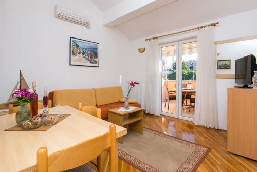 a living room with a table and a couch at Apartments Miramare & Campara in Dubrovnik