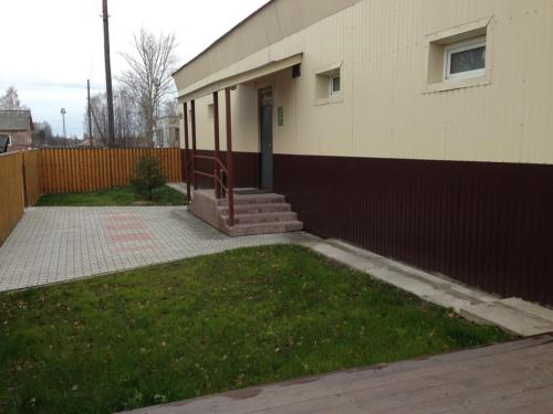 un edificio con porche y escaleras junto a una valla en Mini-Hotel Comfort, en Suoyarvi