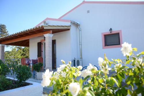a white house with a window and white flowers at Villa Vicky Corfu in Agios Ioannis