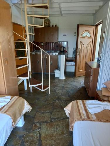 a room with two beds and a kitchen with a staircase at Villa Rena in Batsi