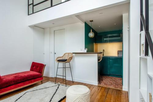 - un salon avec un canapé rouge et un fauteuil rouge dans l'établissement Studio Emerald - Welkeys, à Paris