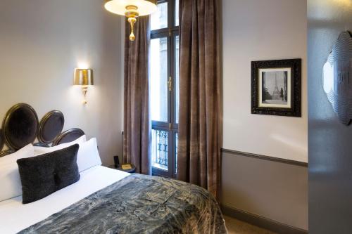 Giường trong phòng chung tại Hotel Lumen Paris Louvre