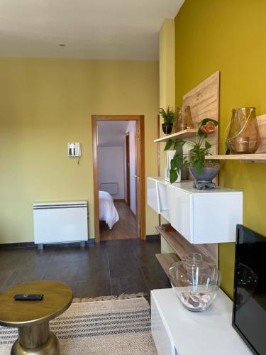 a living room with yellow walls and a table at Mirador Islas de Arousa in Ribeira