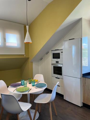 a kitchen with a table and chairs and a refrigerator at Mirador Islas de Arousa in Ribeira