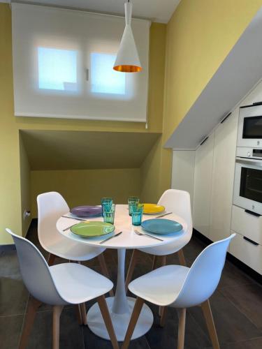 a dining room with a white table and chairs at Mirador Islas de Arousa in Ribeira