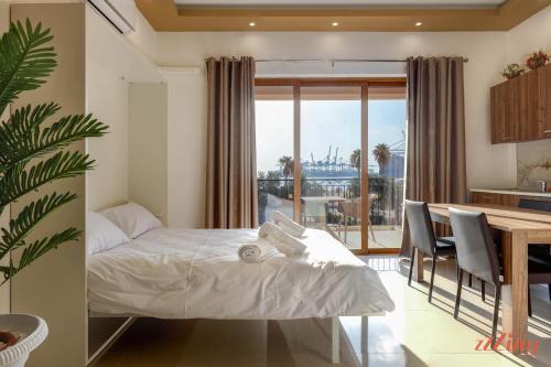 a bedroom with a bed and a table and a kitchen at Luxurious Duplex Seafront Apt w Amazing Sea Views in Birżebbuġa