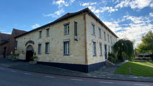 a large brick building on the side of a street at Carré Hotel Zuid-Limburg in Hulsberg
