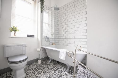 Poachers Cottage في ليبرن: حمام مع مرحاض وحوض استحمام