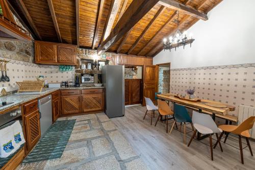 una cucina con armadi in legno, tavolo e sedie di Casas da Fonte - Turismo Rural a Vila Verde