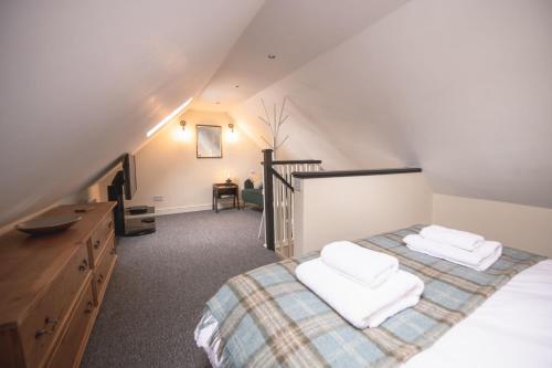 Poachers Cottage في ليبرن: غرفة نوم في العلية مع سرير مع وسادتين بيضاء