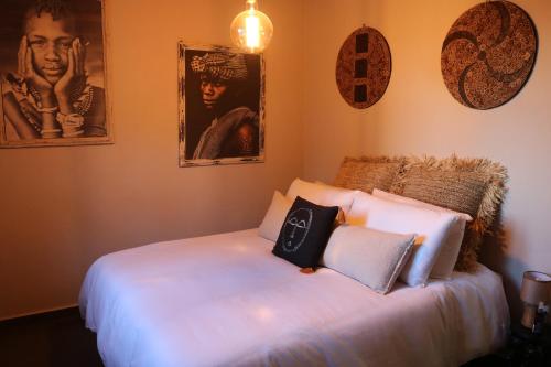 a bed in a room with two pictures on the wall at Casa Eden - Mountain View, Infinity Pool Boutique resort - Adults only in Málaga
