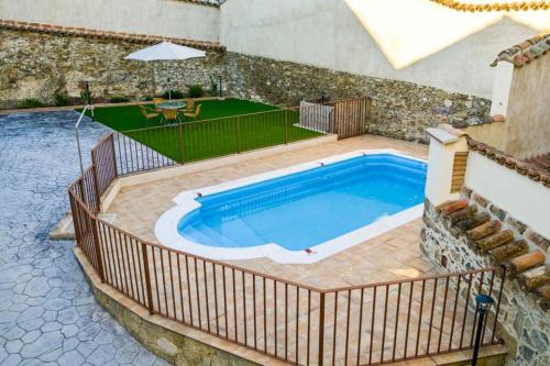 una piscina en un patio trasero con una valla alrededor en A - Apartamento elegante con piscina compartida, en Torrico