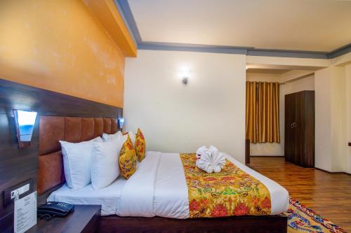 a hotel room with a bed and a desk at Muscatel Grand Silkroute - 300 Mts from MG Marg in Gangtok
