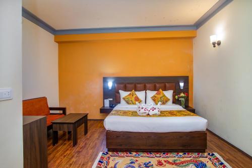 a hotel room with a bed and a desk and a room at Muscatel Grand Silkroute - 300 Mts from MG Marg in Gangtok