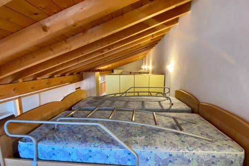 NiardoにあるL'Oasi nel Borgoのベッドルーム(ベッド2台付)が備わる屋根裏部屋です。