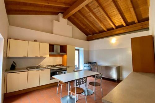 a kitchen with a table and chairs in a room at L'Oasi nel Borgo in Niardo