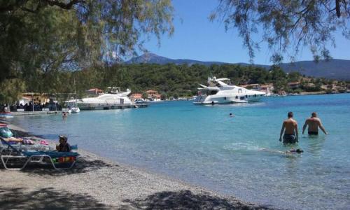 a group of people in the water at a beach at "Patra's" Apartments Patra in Poseidónion