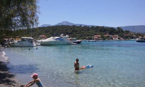 a man and woman in the water at a beach at "Patra's" Apartments Patra in Poseidónion