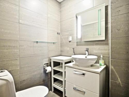 a bathroom with a sink and a toilet and a mirror at Keskuskuja 5 A1 ja A4, Levin Alppikeskus in Levi