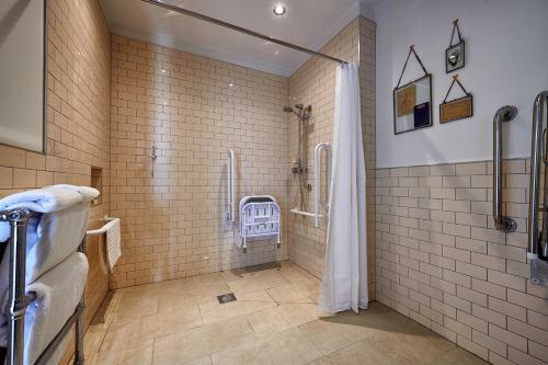 a bathroom with a shower and tiled walls at The Boathouse in Bath