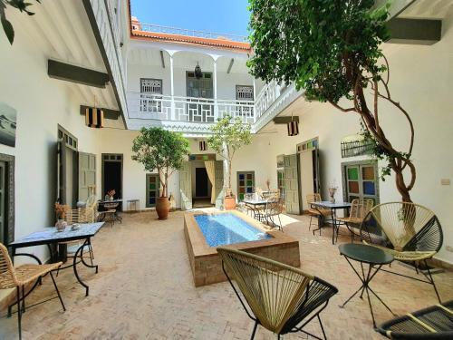 un patio con piscina, mesas y sillas en Riad Dar Zouar & Spa, en Marrakech