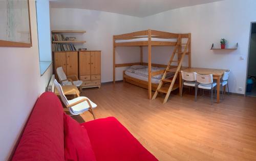 a living room with a red couch and a bunk bed at Apartmány Čertovka in Harrachov
