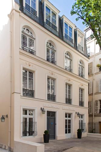 a large white building with windows and a door at Timhotel Opéra Blanche Fontaine in Paris