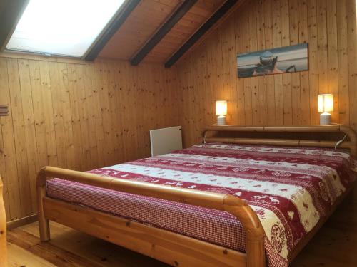 a bedroom with a bed in a room with wooden walls at L'Arpille in Salvan