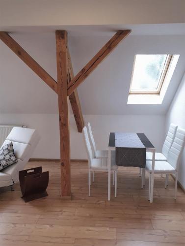 ein Esszimmer mit einem Tisch und weißen Stühlen in der Unterkunft Vogelnest Riesa in Riesa