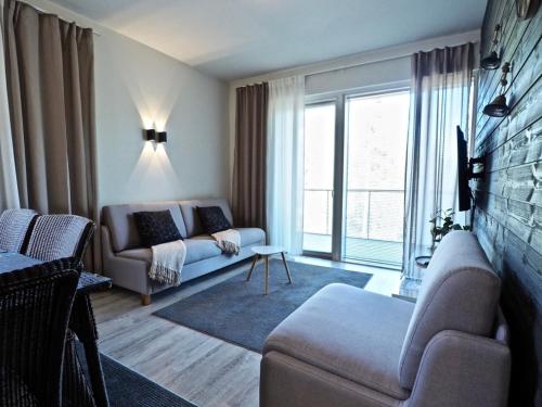 a living room with a couch and a large window at Lomavuokra Alpine Chalets Tunturinlaita in Levi