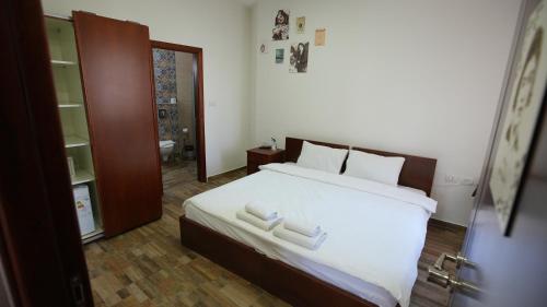 une chambre avec un lit avec deux serviettes blanches dessus dans l'établissement Alrowwad Guest House, à Bethléem