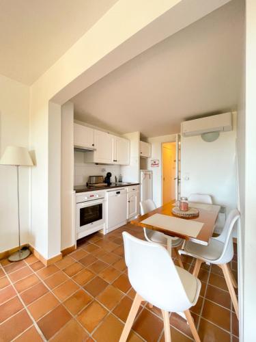 une cuisine avec des armoires blanches et une table et des chaises dans l'établissement Superb Apartment With Balcony Near The Beach, à Saint-Raphaël