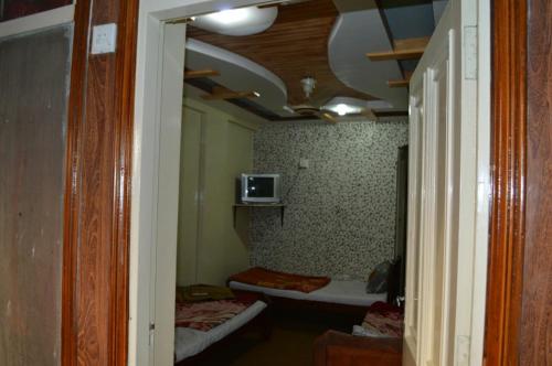 a room with two beds and a tv on the ceiling at Hotel Deluxe in Kachāhri