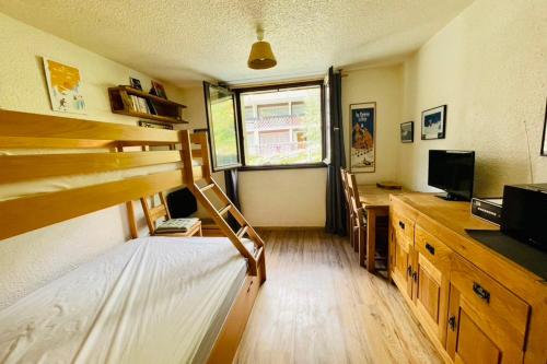 Un dormitorio con una litera y un escritorio con una computadora. en Charming Studio In The Heart Of Saint Chaffrey, en Saint-Chaffrey