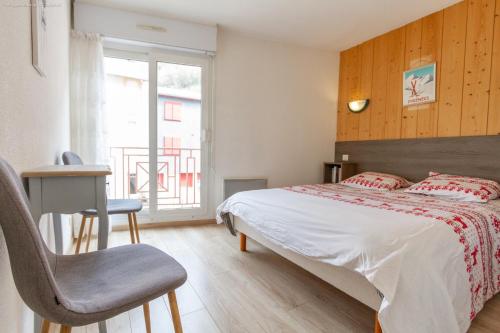 Appartement centre ville parking balcon et wi fi في كوتيريه: غرفة نوم بها سرير وكرسي ونافذة