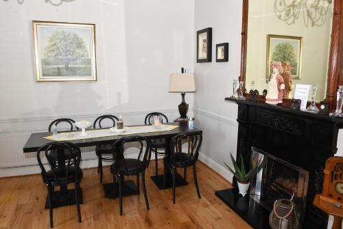 a dining room with a table and chairs and a fireplace at Railway House Guest House in Mullingar