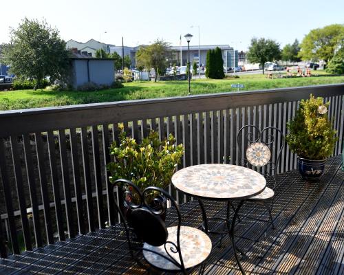 a table and chairs on a balcony with a view of a park at Railway House Guest House in Mullingar