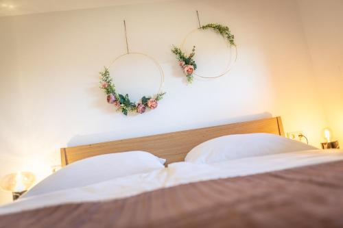 a bedroom with two wreaths on the wall and a bed at Kranach 5 - Wohnen beim Wein in Gamlitz
