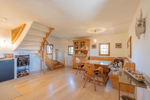 a living room with a staircase and a table and chairs at Kranach 5 - Wohnen beim Wein in Gamlitz