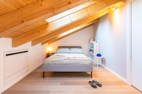 1 dormitorio con cama y techo de madera en ALTIDO Contemporary apartments in historical Giambellino-Lorenteggio, en Milán