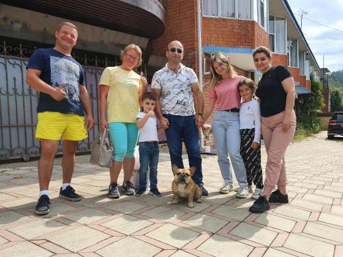 un grupo de personas posando para una foto con un perro en Chemitka Chemitokvadzhe Hotel, en Chemitokvadzhe