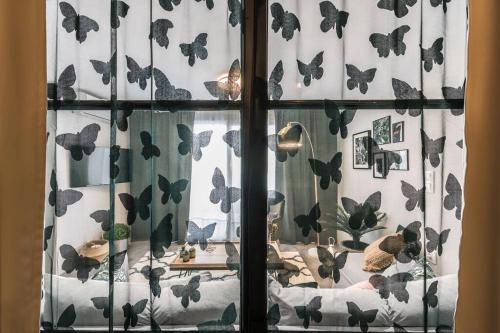 a window with butterflies on the curtains in a room at The Boutique in Athens