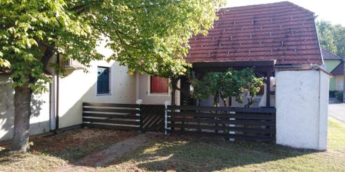 a house with a wooden fence and a tree at Apartmán Perspekta 196 in Čatež ob Savi