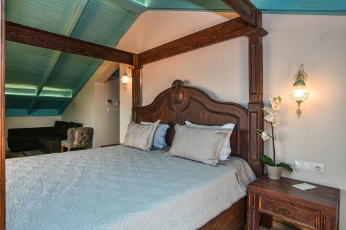 a bedroom with a canopy bed and a living room at Orchis Hotel in Ayvalık