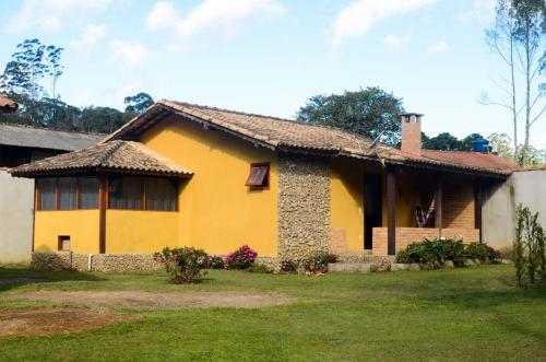レゼンデにあるAconchego De Minas Chalés Visconde de mauáの黄色い家
