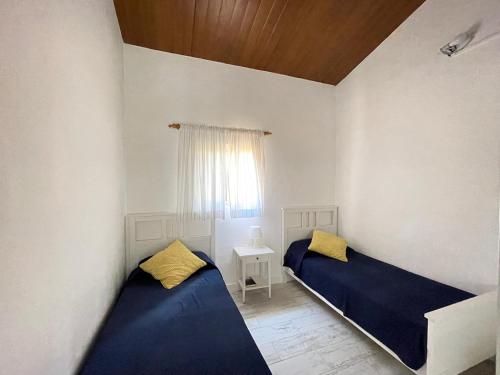 Un dormitorio con dos camas y una ventana. en La Casita de la Parra, El Hierro, en Tamaduste