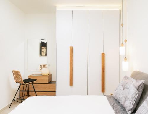 a bedroom with a bed and a chair at ROOF GARDEN SUITE in Matala