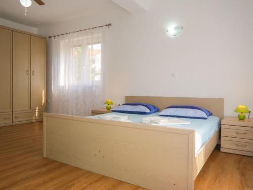een slaapkamer met een groot bed met blauwe kussens bij Apartment Vera - MLK325 by Interhome in Malinska
