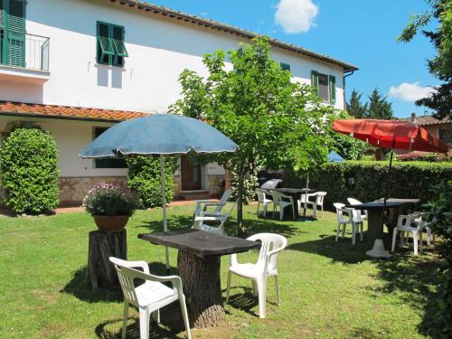 eine Terrasse mit Tischen, Stühlen und einem Sonnenschirm in der Unterkunft Locazione Turistica L'Uccelliera - SMN130 in Canneto